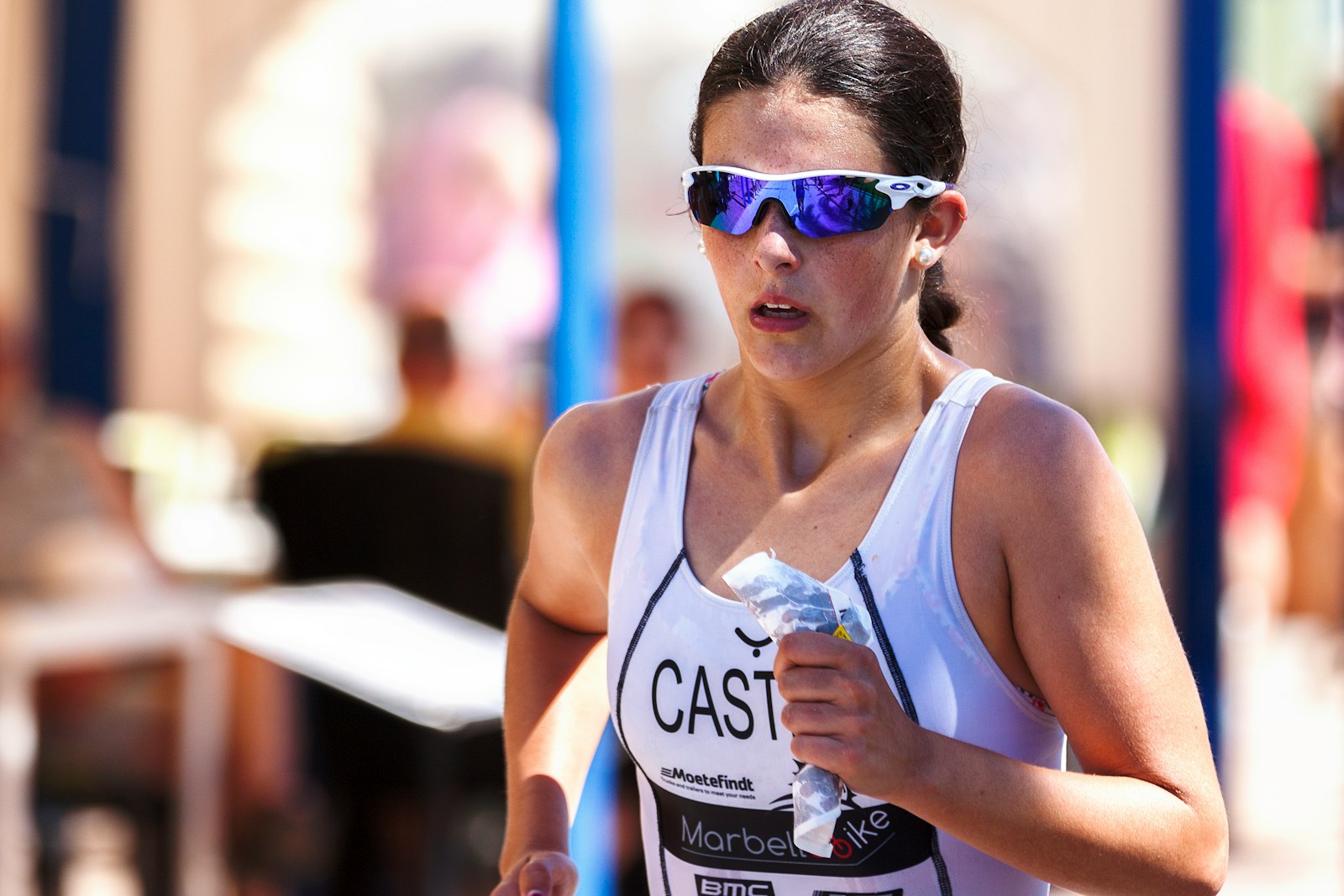 woman wearing blue-lens sunglasses and white tank top